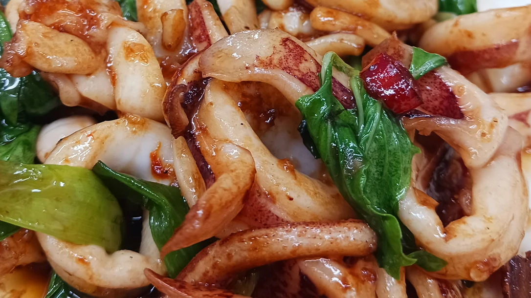 Wandering through the vibrant night market, the aroma of grilled squid and fried snacks fills the air, enticing passersby to indulge.