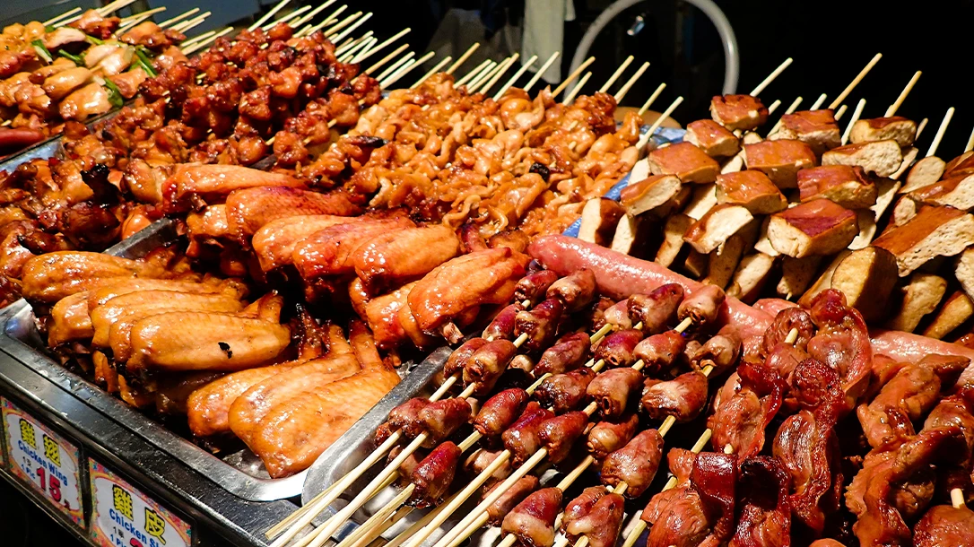 As darkness falls, the night market comes alive with colorful lanterns illuminating stalls brimming with fresh seafood and savory treats.