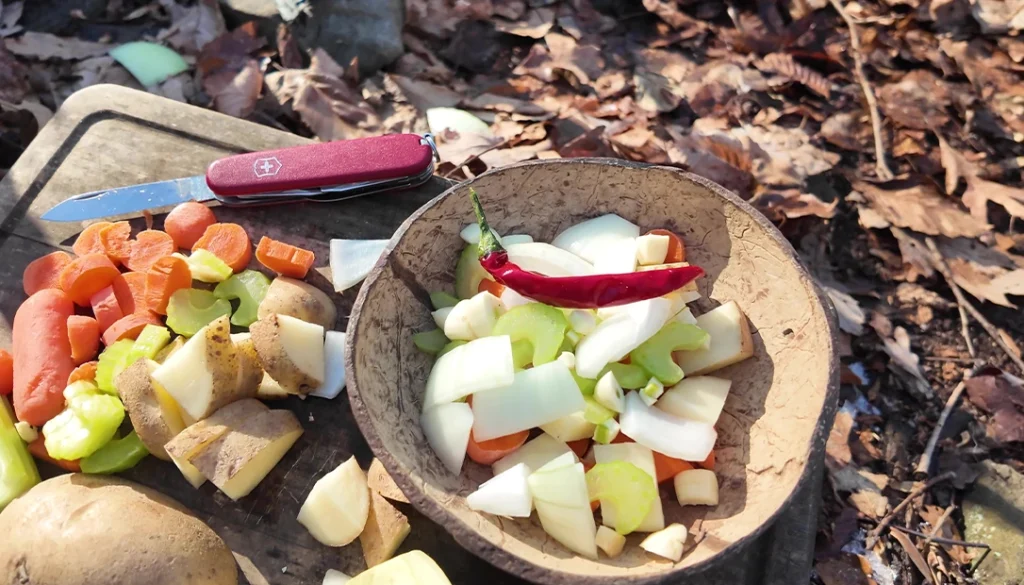 Wind and wood work together, fueling a blazing campfire that promises a meal worth the effort.
